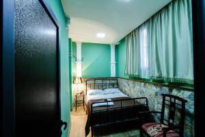 a bedroom with green walls and a bed and a window at MGA Hostel & Tours in Yerevan