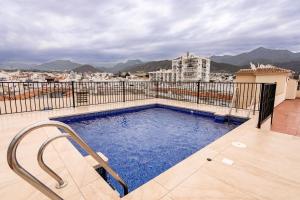 a swimming pool on the roof of a building at Carabeo P Milenio 1 piso 2 1 sea view in Nerja