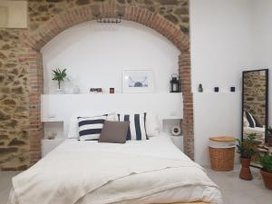 1 dormitorio con 1 cama grande en una pared de ladrillo en Casa Antico Forno, en Manciano
