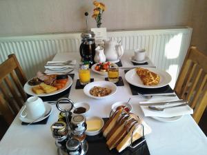 South Lodge Guest House في بريدلينغتون: طاولة عليها طعام ومشروبات للإفطار