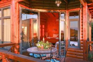 a porch with a table and a bed in a room at Between Water and Sky in Neot Golan