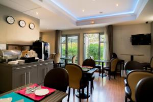 a dining room with tables and chairs and a unintention at Top Motel in Istres