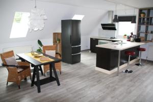 a kitchen with a table and a black refrigerator at Wind & Wasser in Emden