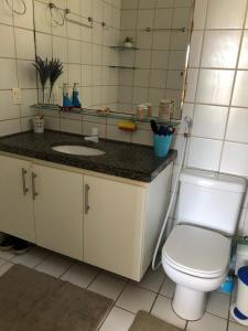 a bathroom with a toilet and a sink and a mirror at Aquaville Resort in Mangabeira