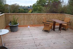 a patio with a table and chairs and a fence at Wind & Wasser in Emden