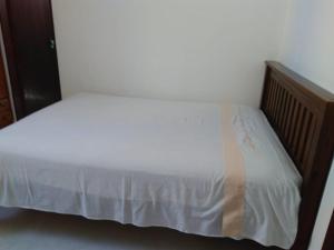 a white bed with a wooden headboard and white sheets at Ótimo apto Praia Bessa in João Pessoa