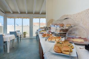 una línea buffet con pan y repostería en los platos en Hotel Biancolilla en San Vito lo Capo