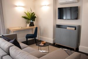 een woonkamer met een bank en een tv bij Heritage House in Stellenbosch