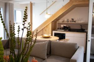 een woonkamer met een bank en een keuken bij Heritage House in Stellenbosch