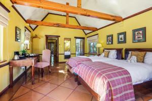 a bedroom with a large bed and a desk at De Hoek Country Hotel in Magaliesburg