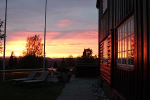 um pôr-do-sol num pátio com cadeiras e um edifício em Lysebu Hotel em Oslo