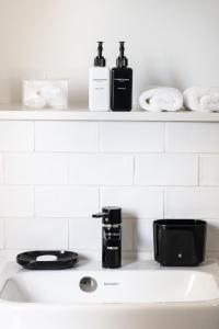 een gootsteen met twee flessen op een plank bij Heritage House in Stellenbosch