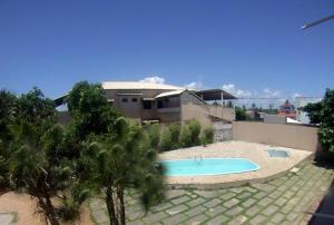 a swimming pool in front of a house at Apto na Praia de Guaibim in Guaibim
