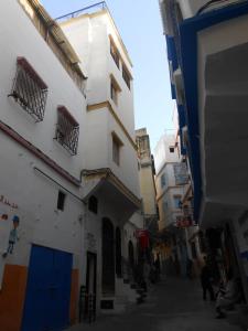 an alley with buildings and people walking down it at Petit Bijou de Tanger in Tangier
