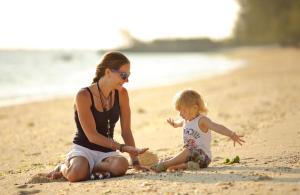 a woman and a child playing on the beach at The Residence Zanzibar in Kizimkazi