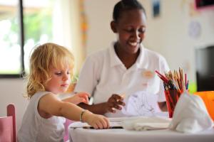 a woman and a little girl sitting at a table at The Residence Zanzibar in Kizimkazi
