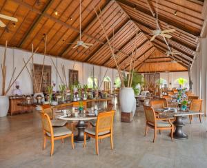 a dining room with tables and chairs and ceilings at The Residence Zanzibar in Kizimkazi