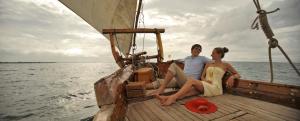 a man and a woman sitting on a boat at The Residence Zanzibar in Kizimkazi