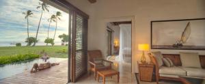 a living room with a view of the ocean at The Residence Zanzibar in Kizimkazi