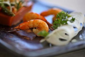 a plate of food with shrimp and vegetables on it at The Residence Zanzibar in Kizimkazi
