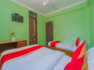 two beds in a room with green walls at Waling Fulbari Guest House in Bālāju