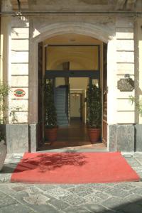 un tappeto rosso è sul pavimento di un corridoio di Hotel La Ville a Catania