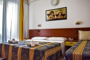 Un pat sau paturi într-o cameră la Hotel Dear Rimini +44 fotografii