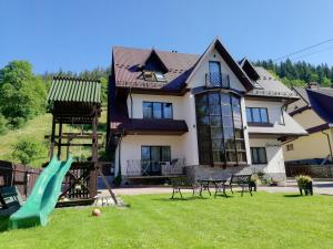 a house with a playground in the yard at Galicówka in Poronin