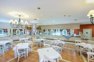 a dining room with white tables and chairs at Royal Suite in Costa Calma