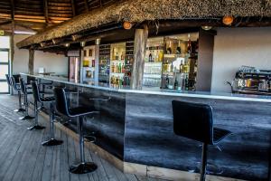 een bar met een rij zwarte barkrukken bij Sibebe Resort in Mbabane