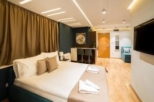 een slaapkamer met een groot bed en een woonkamer bij Belgrade Center Luxury Apartments in Belgrado