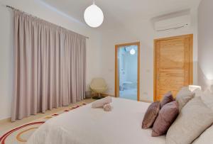 a bedroom with a white bed with pillows on it at Luxury Apt with Side Seaviews and Pool, Best Location in Sliema +36 photos