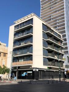 a large white building on a city street at Luxury 2bdrm balcony & parking close to the Beach in Tel Aviv