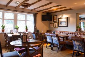 a restaurant with tables and chairs and a bar at The Foxglove by Innkeeper's Collection in Kirkburton