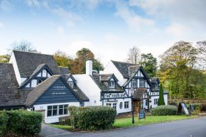 una casa blanca con techo negro en The Foxglove by Innkeeper's Collection, en Kirkburton