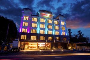 a hotel with a lit up building at night at Hotel Span International in Cochin