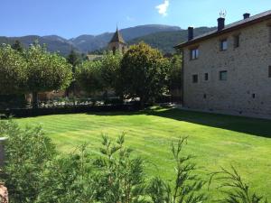 un gran patio de césped junto a un edificio en Cal Pedrals Pairal, en Urús