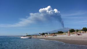 a fire erupting on a beach with people on the beach at Villa Bea in Giardini Naxos