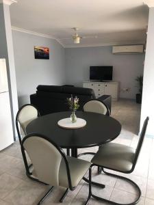 uma mesa preta e cadeiras numa sala de estar em Guesthouse on Dolphin em Safety Bay