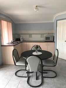 uma cozinha com mesa e cadeiras num quarto em Guesthouse on Dolphin em Safety Bay