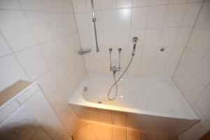 een witte badkamer met een douche en een bad bij Großzügige Familienwohnung - mit grossen Esszimmer in Juist