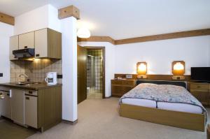 a bedroom with a bed and a kitchen with a sink at Versalerhof in Ischgl