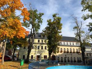 a building with a pool in front of it at Aparthotel Deutscher Kaiser Ferienwohnungen in Kurort Oberwiesenthal