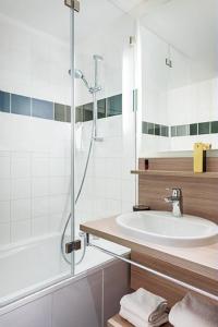 y baño con ducha, lavabo y bañera. en ibis Styles Paris Velizy, en Vélizy-Villacoublay