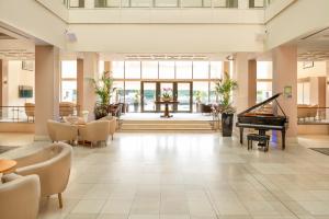 un vestíbulo con piano, mesa y sillas en Copthorne Hotel Newcastle en Newcastle