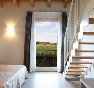 een slaapkamer met een deur naar een veld bij Agriturismo Corte Foscara in Malcontenta