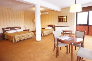 マルキにあるHotel Mistralのベッド2台、テーブルと椅子が備わるホテルルームです。