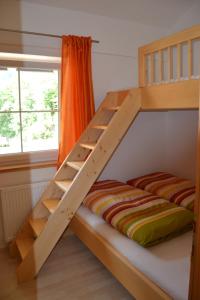 ヴィルゲンにあるApartment Santnerhofの木製の二段ベッド(はしご付)が備わる客室です。