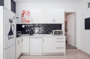 een witte keuken met een koelkast en een magnetron bij 16 Benal Acogedor y en 1ª linea in Benalmádena