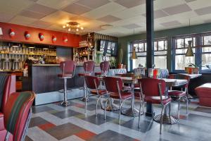 a restaurant with red chairs and a bar at Wittrup Motel in Albertslund